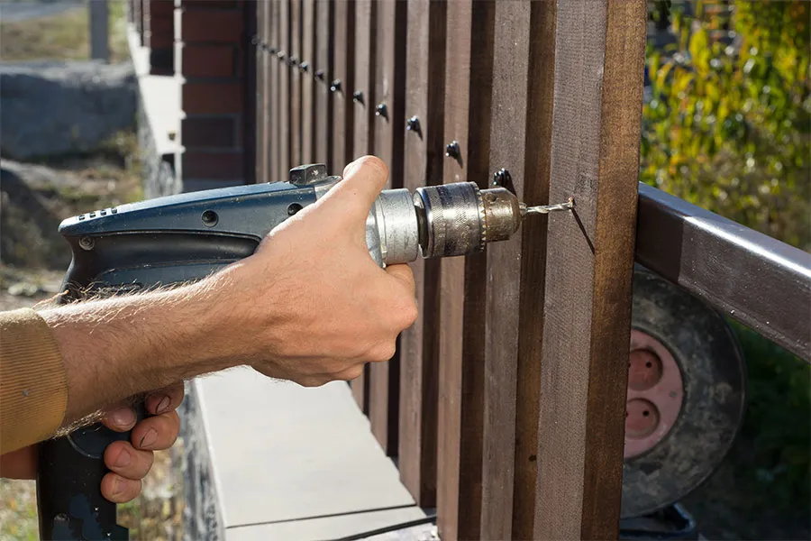 man installing wooden fence